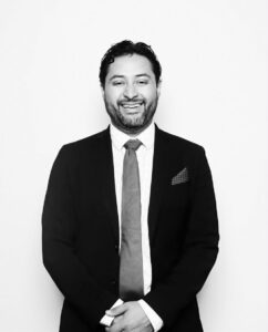 Professional Chicago DJ smiling in formal attire for Clik Entertainment.
