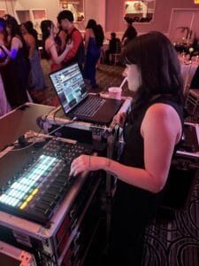 Chicago DJ performing at an event with DJ equipment and dancing crowd.