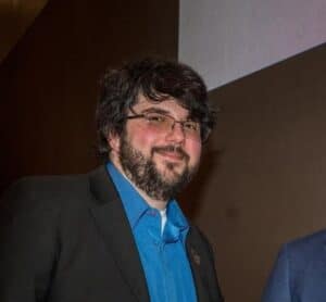 Chicago DJ at Clik Entertainment event with professional attire and glasses.